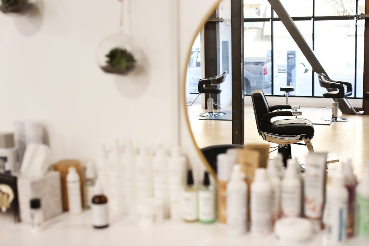 Pflegeprodukte auf der Ablage, dahinter die Salonstühle